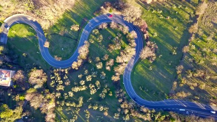 Aerial view of curved road and cars in the mountain on sunny day