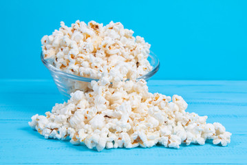 popcorn in a glass bowl on a blue table