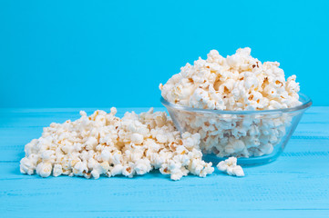 popcorn snack in a glass bowl on a blue table