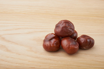 Chestnuts. Buckeye. Autumn mood. Sweet chestnuts on a wooden background.