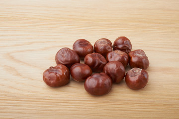 Chestnuts. Buckeye. Autumn mood. Sweet chestnuts on a wooden background.
