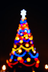 The lights of the Christmas tree, the silhouette from the bokeh