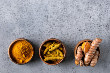 Fresh and dry root turmeric, curcuma powder on grey . Space for text. Healthy spice immunity. Top view. Natural antiseptic.
