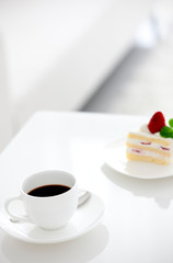 テーブルに置かれたコーヒーカップとケーキ