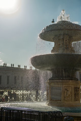 Zabytki na placu Św. Piotra. Na pierwszym planie ogromna fontanna, a w oddali widać bazylikę świętego Piotra, Włochy. - obrazy, fototapety, plakaty