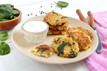 Pancakes with cabbage and spinach. Juicy vegetable cutlets on a plate with sour cream. Diet menu. Lenten dish.