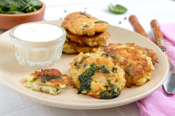 Pancakes with cabbage and spinach. Juicy vegetable cutlets on a plate with sour cream. Diet menu. Lenten dish.