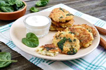 Pancakes with cabbage and spinach. Juicy vegetable cutlets on a plate with sour cream. Diet menu. Lenten dish.