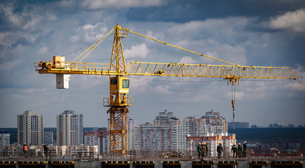 Construction crane and workers at a multi-storey building site