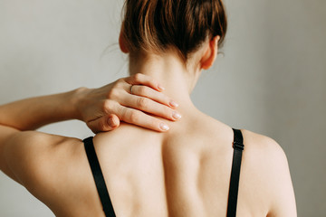  Neck and back injuries, and fatigue at work. The zone of injury, the image on a blank background. A spasm in the girl's neck.