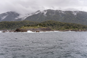 waves and light house at St. Anne cape on fjord shore,  Milford Sound, New Zealand