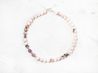 necklace from pink quartz beads on gray background