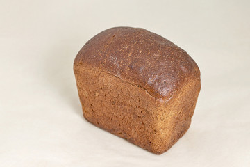 The grey loaf of rye bread, an assortment of bread and bakery products. Closeup on a light background