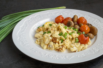 scrambled eggs with mushrooms and cherry.