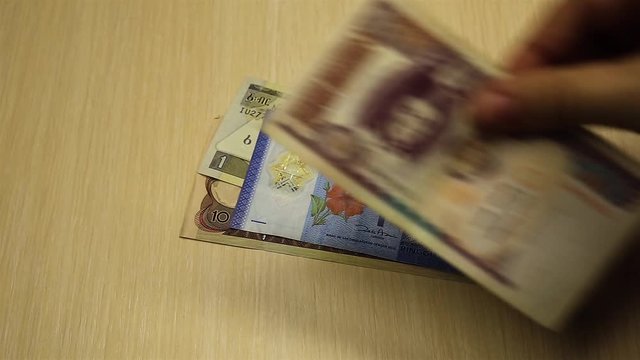 male hand lays out banknotes of different states on the table. Account of money.