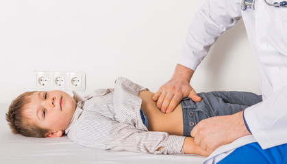 Obraz premium The doctor examines the belly child at clinic.