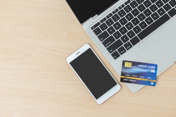 smartphone credit card laptop computer on wood table, business object, work online concept.