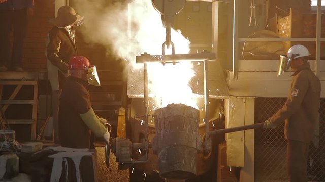 Room for manufacture of metal products by casting. Casting shop for gassified models. Molten metal pouring out of furnace. Liquid metal from blast furnace. Molten metal foundry. Pouring molten steel