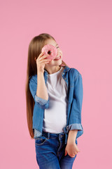 girl playing with a donut on a pink background.