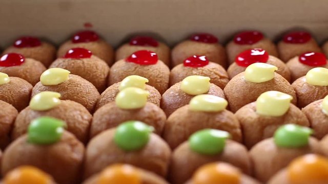 Dough balls with colourful castard in paper box, Colorful and delicious donuts. Dolly shot of Homemade and yummy donut balls.