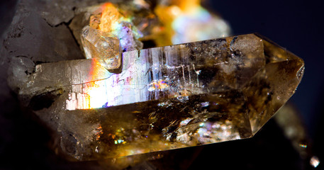 Amazing natural light reflections on healing Smokey Quartz wild jewels. Texture of gemstone with rainbow effect.
