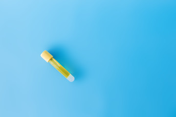 Alone test tube with vaccina on a blue background, flat lay, copy space
