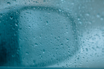 Obraz premium Rainy weather. First rains, inside view. Raindrops on a car side window