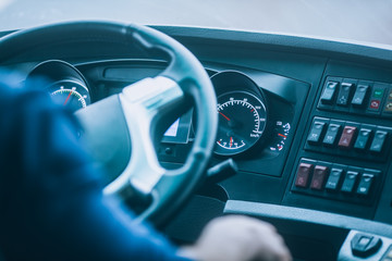 Bus driver, driving a bus or truck: view of the steering wheel and dashboard.