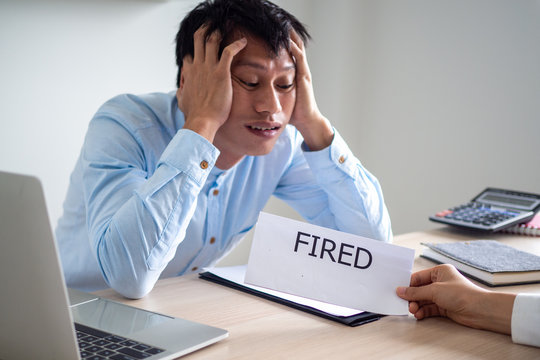 A business man looks and shows signs of stress and panic when the boss sends a dismissal letter. The concept of being laid off
