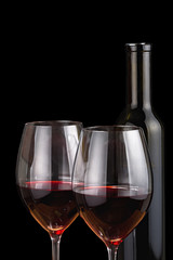 isolated two glasses and bottle with red wine