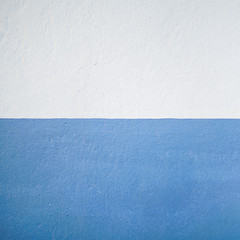 Abstract background of cement wall paint with white and blue color a half