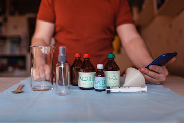 A middle aged man reading receipt from mobile phone and doing hand sanitizer at home