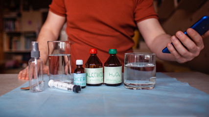 A middle aged man reading receipt from mobile phone and doing hand sanitizer at home