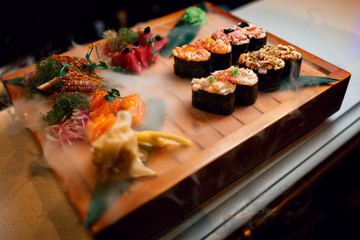 Japanese Cuisine. set of gunkan sushi and sashimi on a brown wooden stand