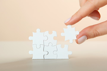 Collect puzzle. Hand and puzzle pieces on the table
