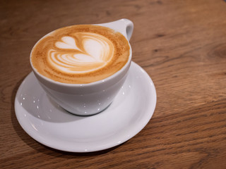 A coffee with a beautiful latte art heart on top