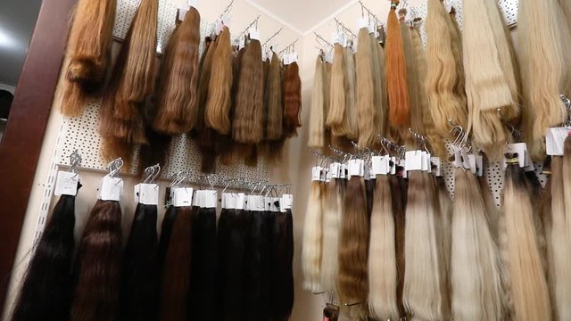 Long fake hair on a bench in a store. Hair Extension Salon