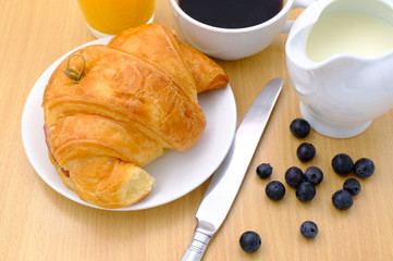 Breakfast served with coffee, orange juice, croissants and fruits. Balanced diet.