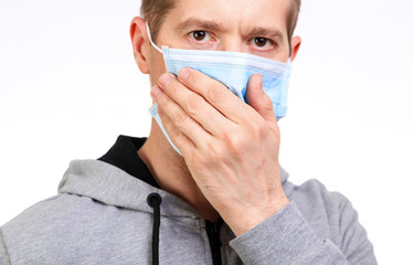 Sports the man in a hood, a medical mask on the person, coughs, isolated, a close up