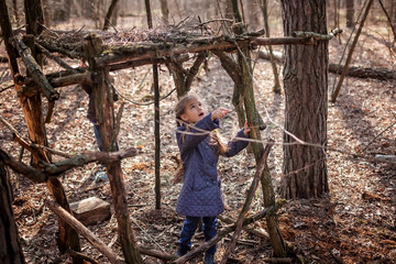 Naklejka na ściany i meble Young adventurers building a wooden habitat in the wild forest during social distant walking