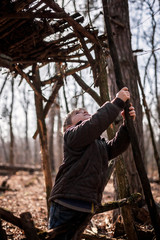 Young adventurers building a wooden habitat in the wild forest during social distant walking