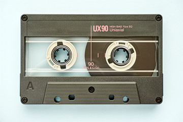 Closeup of plastic audio tape cassette on light blue background. Vintage background.