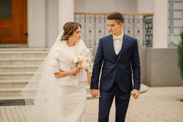 Beautiful wedding couple. Bride and groom at wedding day walking outdoors. Bridal couple, Happy Newlyweds.