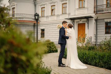 Happy bride and groom on their wedding. Bride and groom at wedding day walking outdoors. Happy couple. Wedding photo. Couple in love.