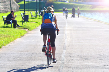 Sporty mature woman rides bicycle in the city