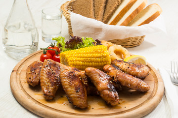 Grilled chicken wings with sweet corn. Close-up shot.