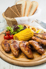 Grilled chicken wings with sweet corn. Close-up shot.