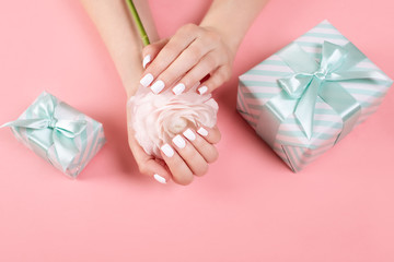 Hands of a beautiful woman on a colorful background. Delicate palm with natural manicure, clean skin. Light pink nails.