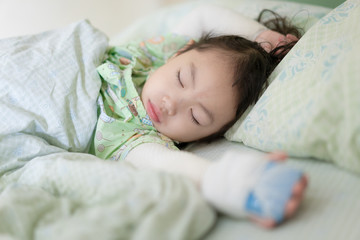 Asian little girl lying in bed at hospital, Baby girl sick from skin allergies, She was wrapped with a bandage on the neck and both arms, Atopic dermatitis (AD).