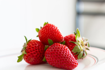 plate of red strawberries on a white background